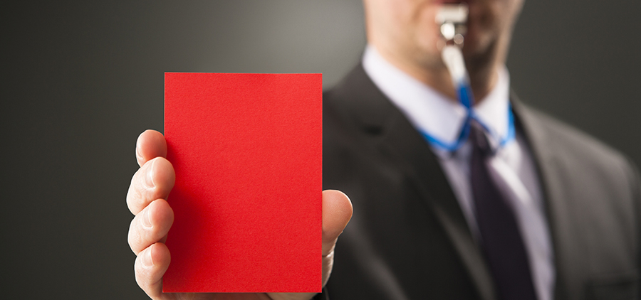 Businesman blows whistle and shows red card