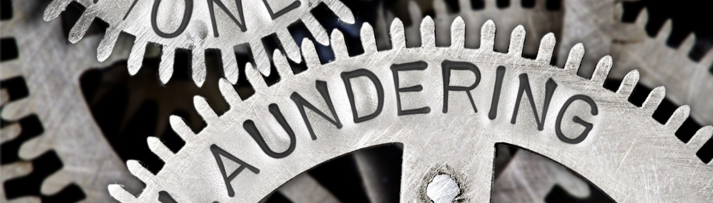 Tooth wheel mechanism with MONEY LAUNDERING letters imprinted on metal surface
