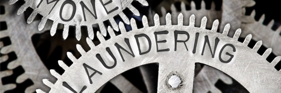 Tooth wheel mechanism with MONEY LAUNDERING letters imprinted on metal surface